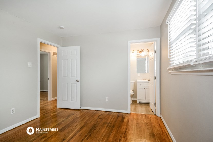 the living room of a home with wood floors and white walls