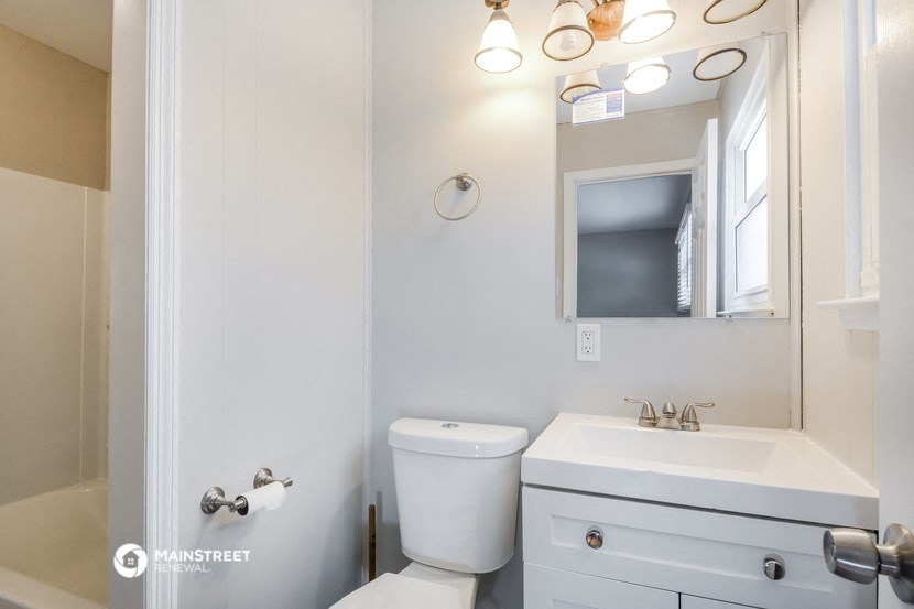 a bathroom with a sink toilet and a mirror