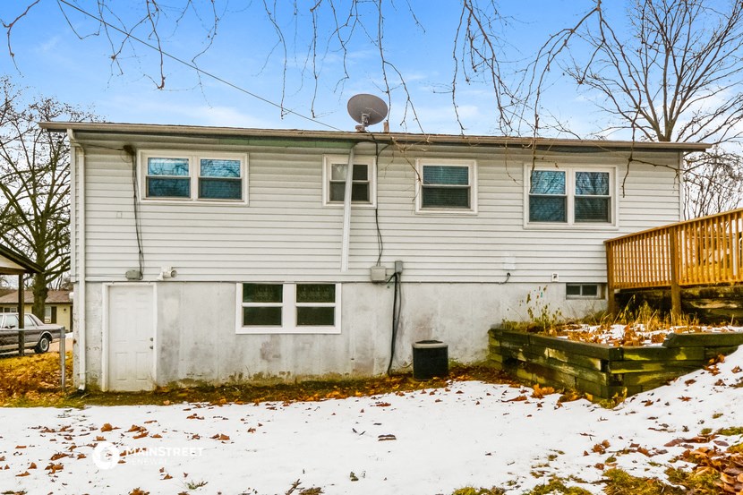 a house with snow on the ground and a satellite dish on the roof