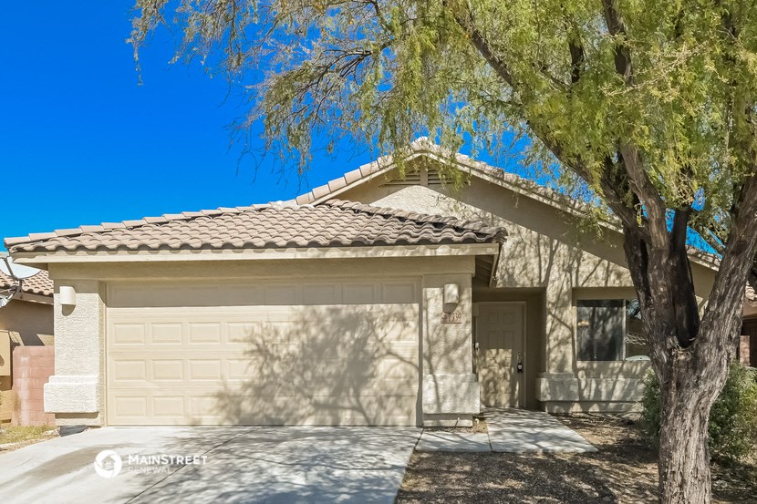 a house with a garage door and a tree