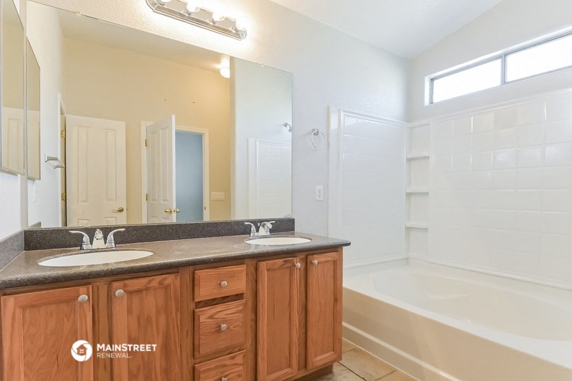 a bathroom with two sinks and a shower and a bath tub