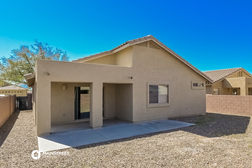 a beige house with a yard and a patio