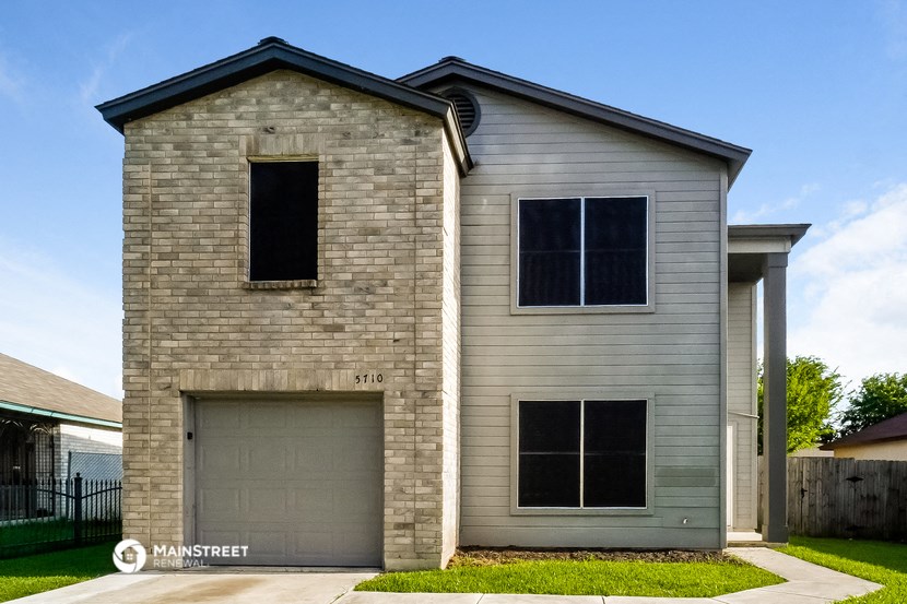 a white brick house with a garage door