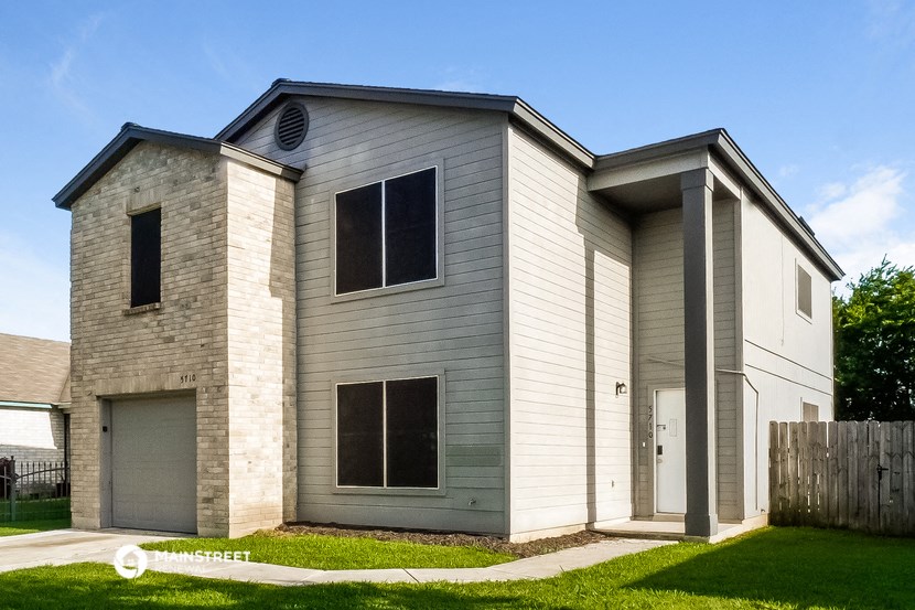 a white house with a garage and a lawn