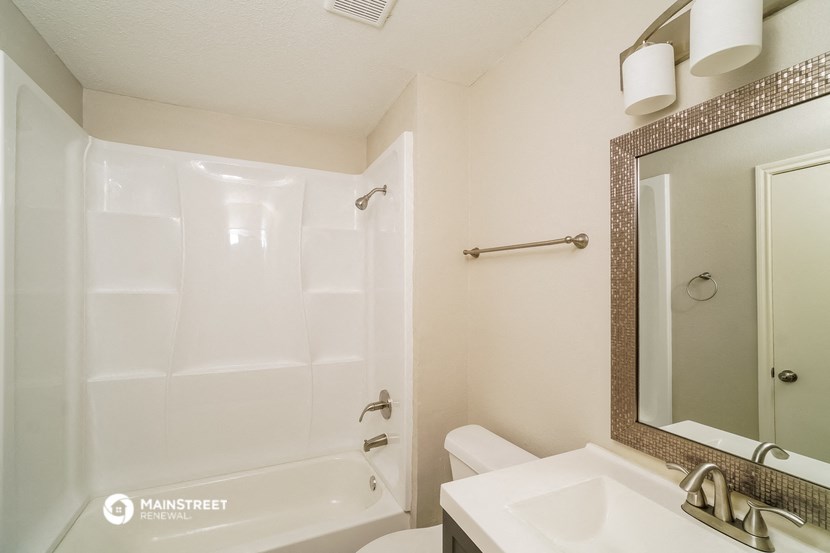 a bathroom with a shower and a sink and a mirror