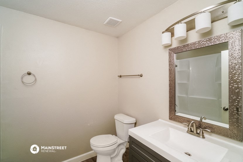 a bathroom with a sink toilet and a mirror