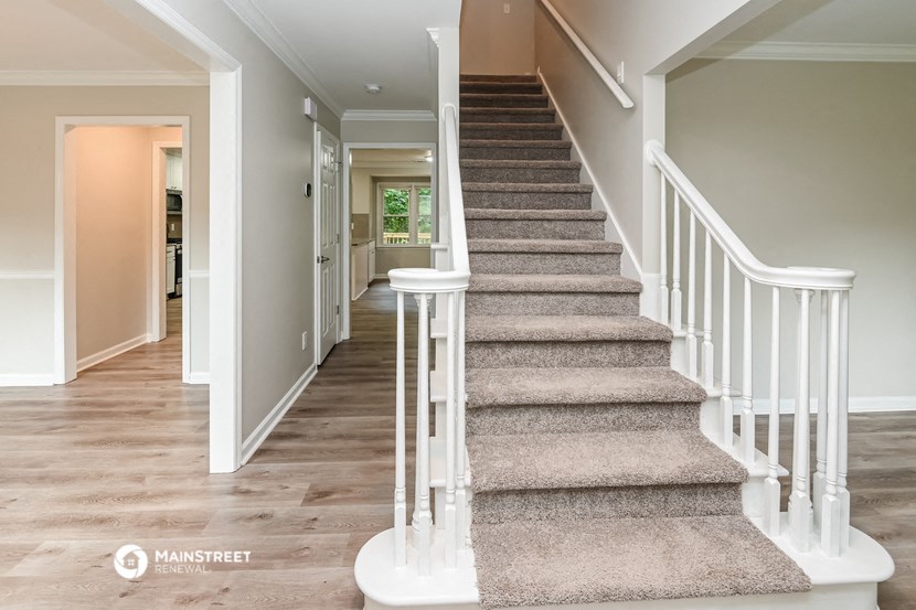 a staircase in a home with carpeted stairs and a hallway