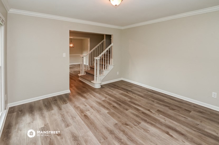 the living room and dining room with the stairs to the second floor