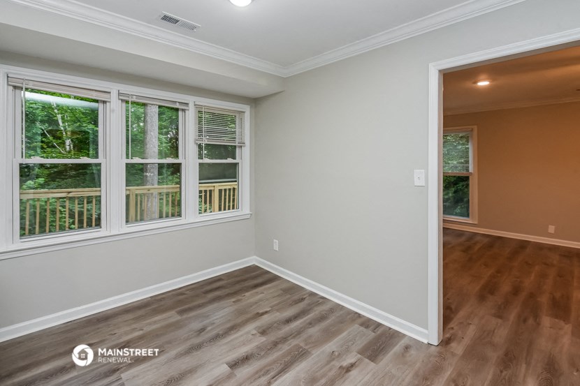 the living room of a new home with wood flooring and large windows
