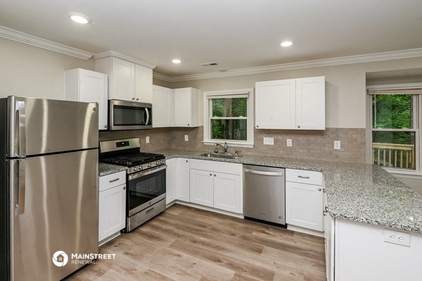 a kitchen with white cabinets and stainless steel appliances