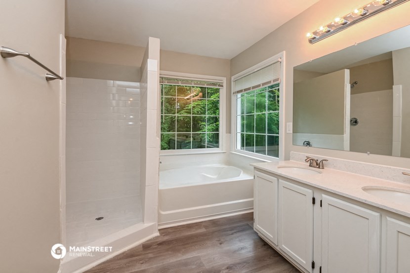 a bathroom with a tub and a sink and a window