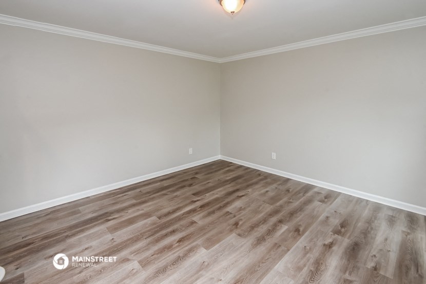 the living room of an empty house with wood flooring