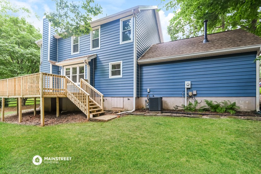 a blue house with a backyard and a deck