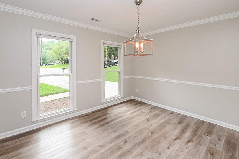 an empty living room with wood floors and a window