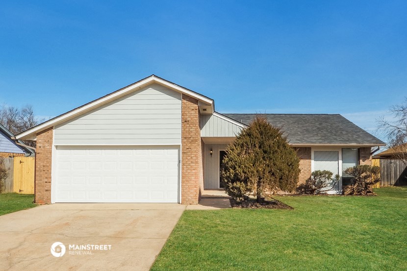 a house with a white garage door and a green lawn