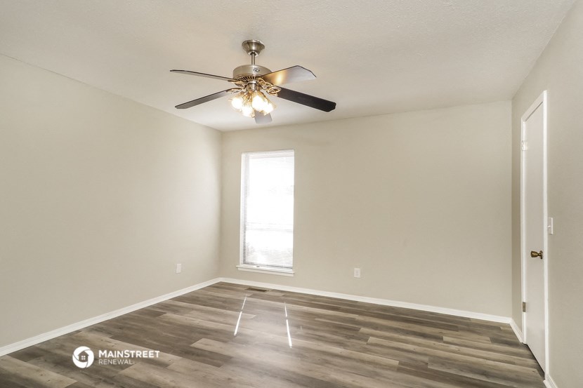 a living room with a ceiling fan and a window