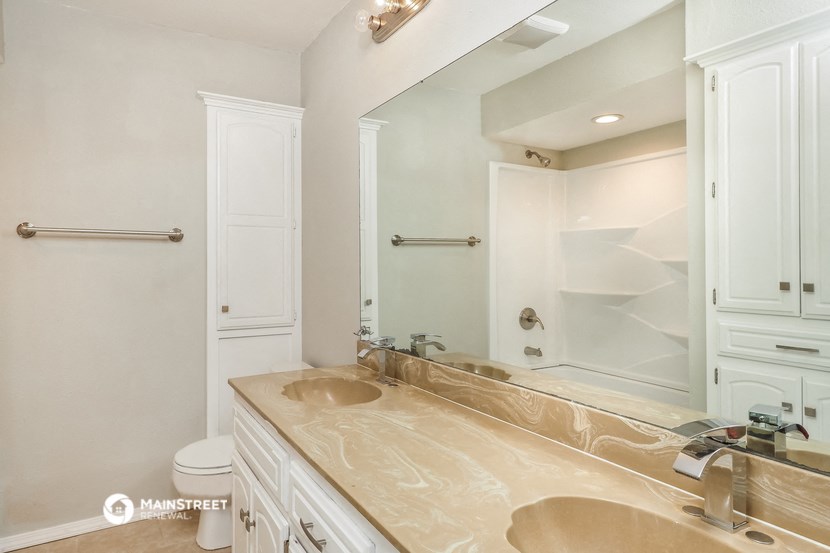 a bathroom with a large mirror and a sink and a toilet