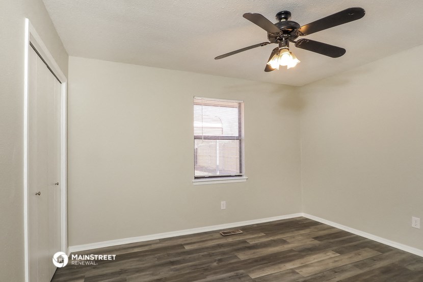 a bedroom with a ceiling fan and a window