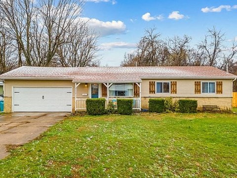 A house with a garage and a driveway in front of it.
