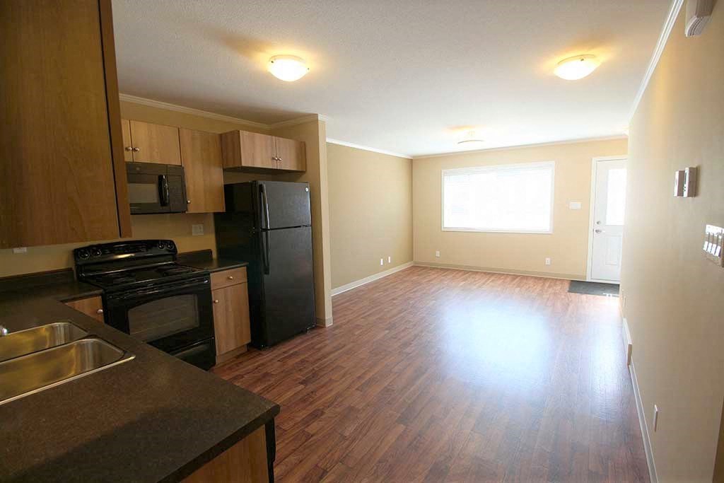an empty kitchen with a stove and a refrigerator