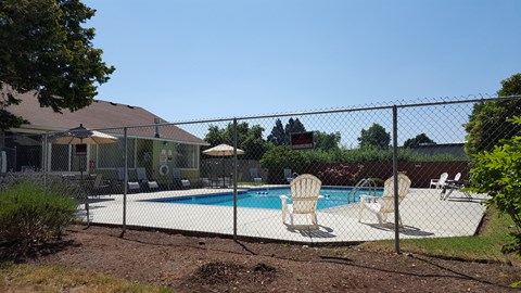 a swimming pool in a backyard behind a chain link fence