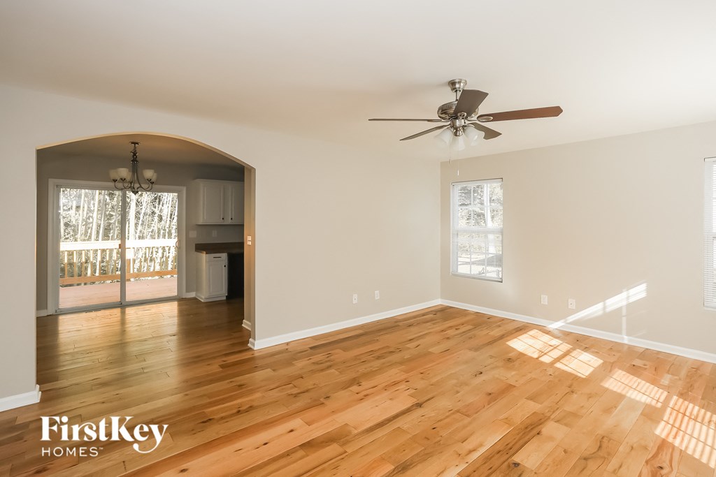 a living room with wood floors and a ceiling fan
