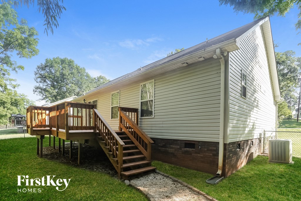the exterior of a tiny home with a deck and a staircase