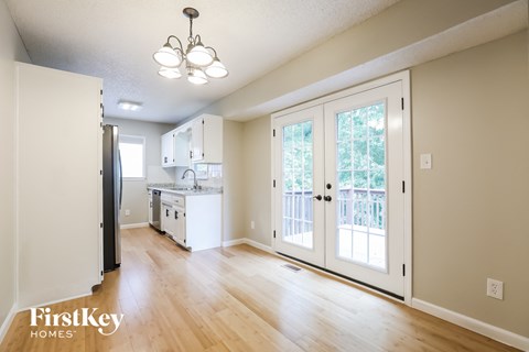 A kitchen with a refrigerator, sink, and cabinets.