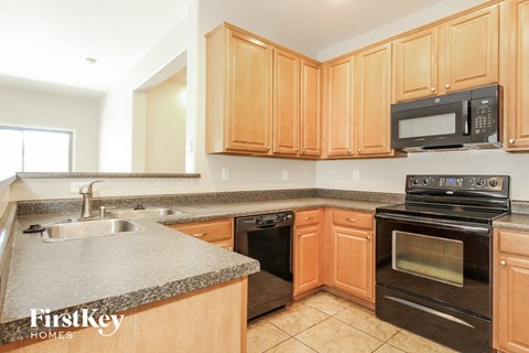 A kitchen with wooden cabinets and black appliances.