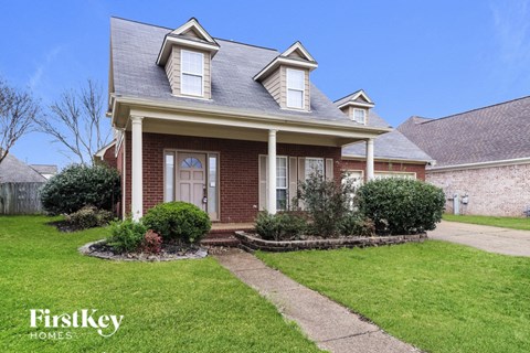 a small brick house with a sidewalk in front of it