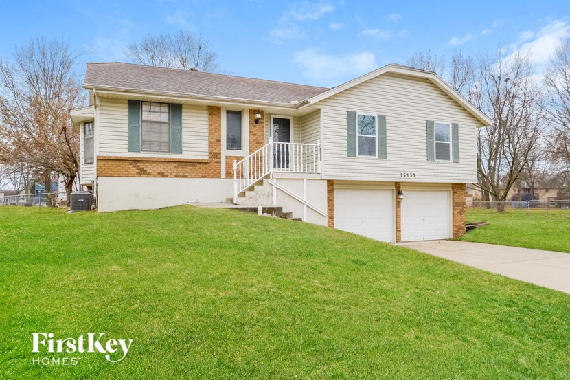 the front of a house with a lawn and a driveway