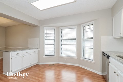 a kitchen with white cabinets and a wood floor