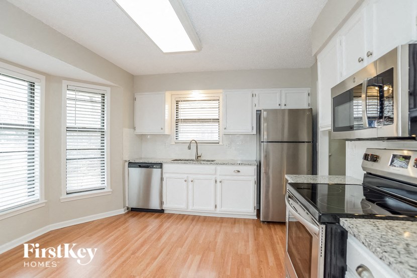 a kitchen with stainless steel appliances and white cabinets