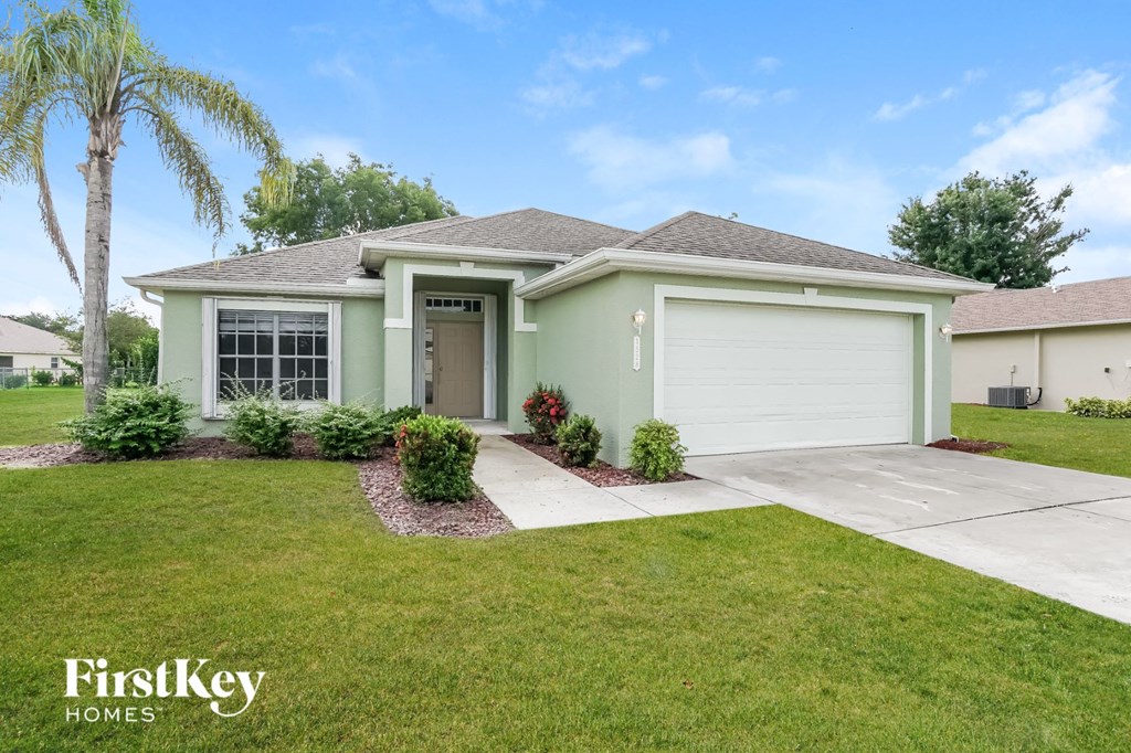 A house with a garage and a driveway in front of it.