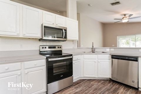 A kitchen with white cabinets and stainless steel appliances.