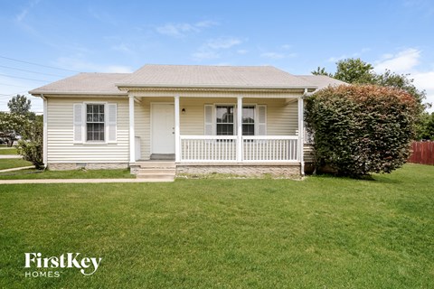A small house with a porch and a white door.
