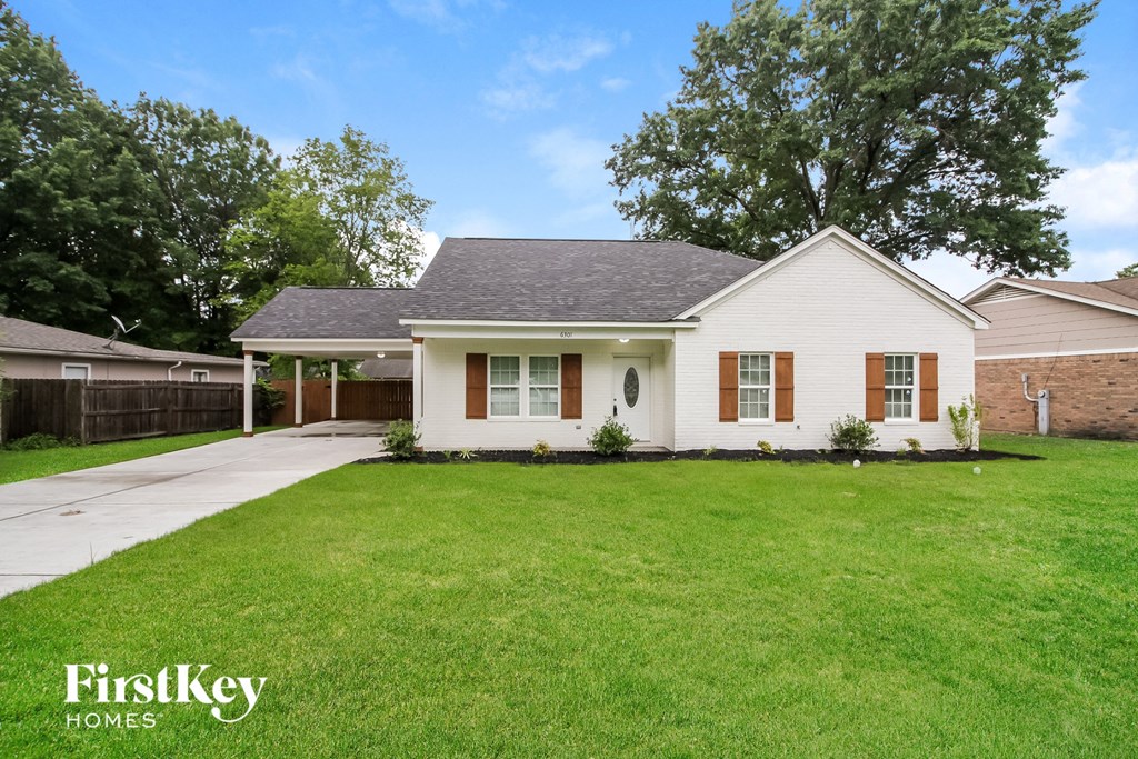a white house with a lawn and a driveway