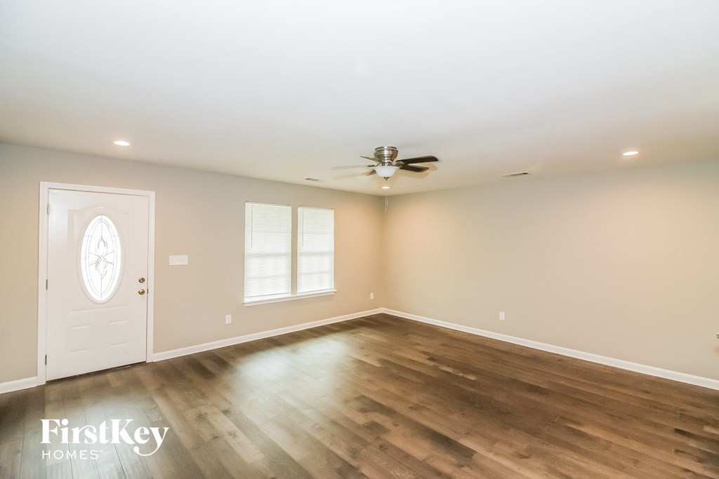the living room with hardwood floors and a ceiling fan