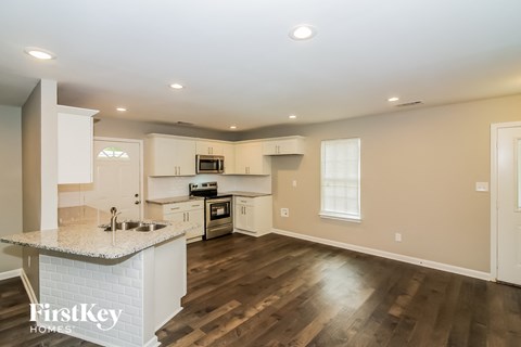 a kitchen with white cabinets and a marble counter top