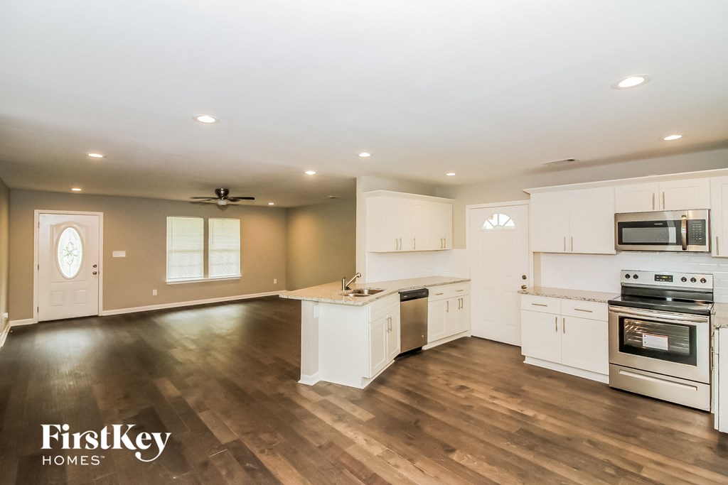 an open kitchen with white cabinets and stainless steel appliances