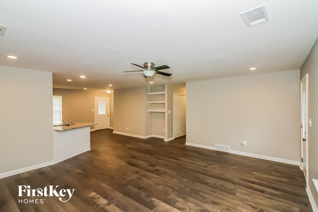 a living room with wood flooring and a ceiling fan