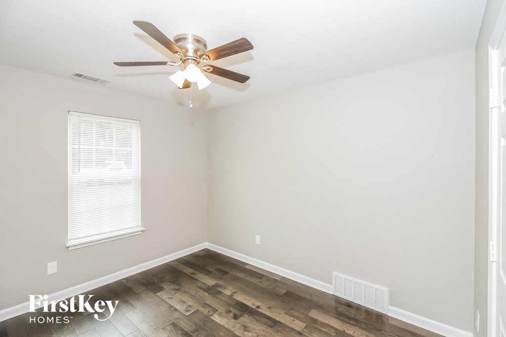 the living room of an empty house with a ceiling fan