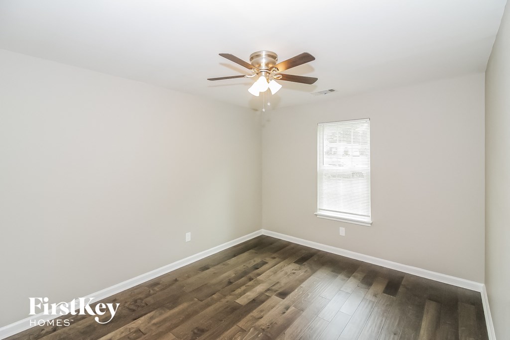 a bedroom with hardwood flooring and a ceiling fan