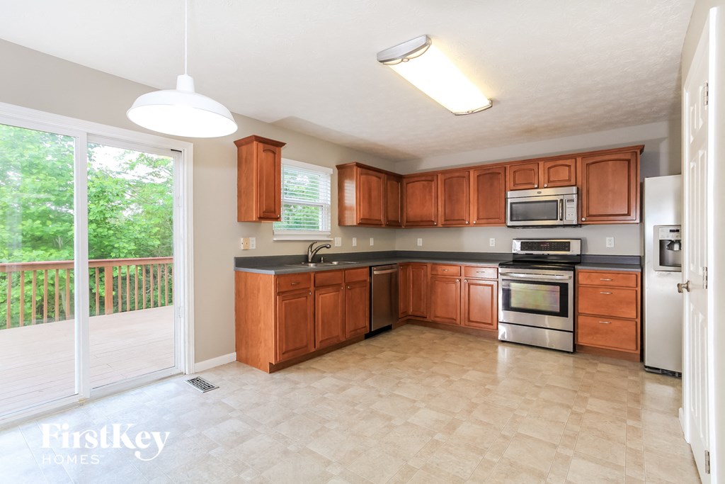 a kitchen with wooden cabinets and stainless steel appliances and a sliding glass door