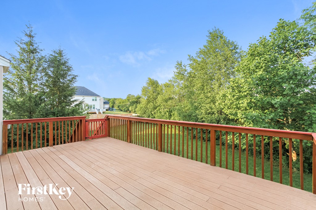 a deck with a view of trees and a blue sky