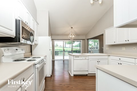 A kitchen with white cabinets and appliances.