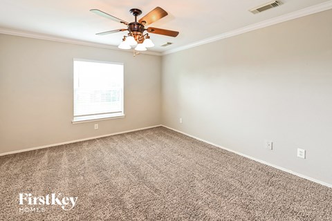a bedroom with carpet and a ceiling fan