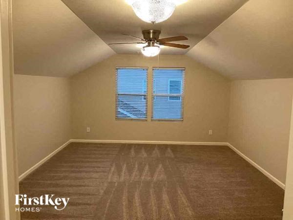 an empty room with a ceiling fan and a window