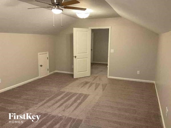 a empty living room with a ceiling fan and a door