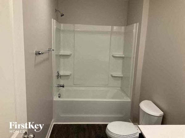 a white bathroom with a shower and a toilet